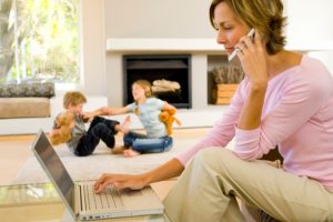 Woman talking on phone and using laptop computer
