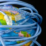 Network cable wrapped around a globe depicting a connected world