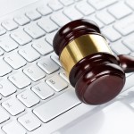 Close up of wooden gavel at the computer keyboard