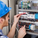 Technician Examining Fusebox With Multimeter Probe