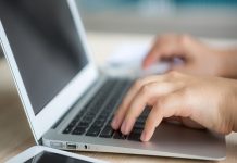 Closeup of business woman hand typing on laptop keyboard