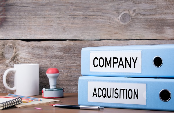 Company and Acquisition. Two binders on desk in the office. Busi