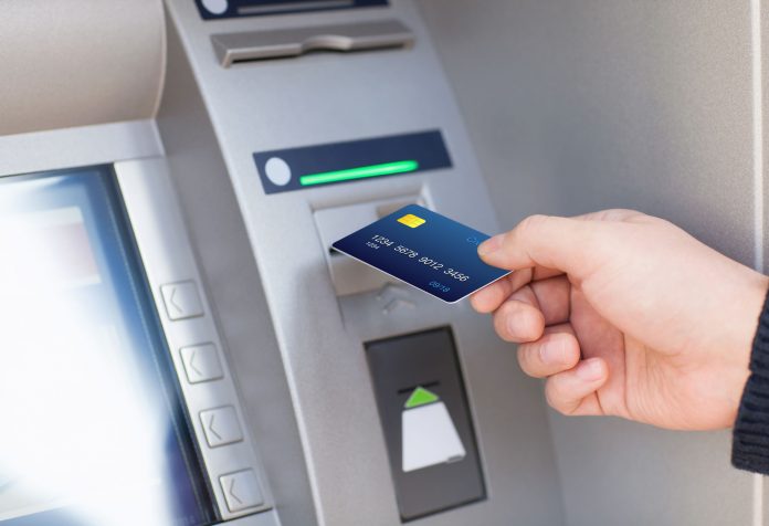 33954756 - man hand puts credit card into atm settore finanziario
