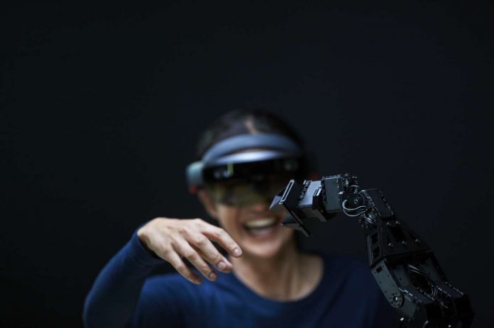 Woman using AR with robotic arm_Brandmanual powerpoint trend digitali
