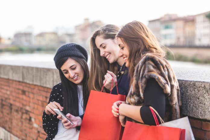 Happy Women with Smart Phone and Shopping Bags SMS Marketing