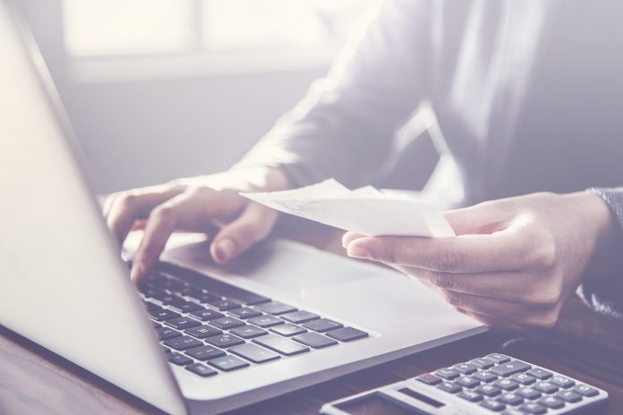 Person paying invoice to computer Fase 2: il decalogo dello smart working efficiente