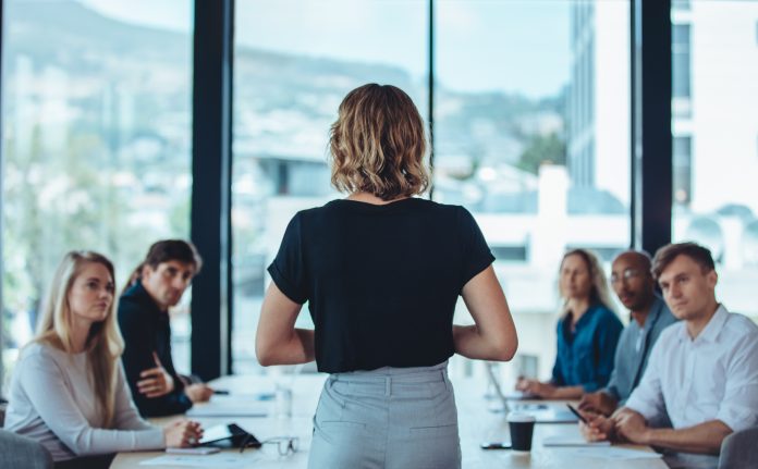 Female business leader conducting a meeting Leadership diffusa: superare la resistenza al cambiamento