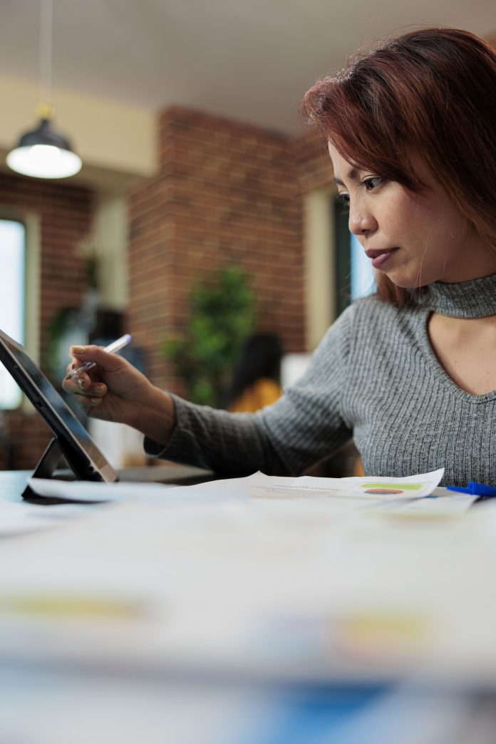 Businesswoman analyzing management graphs on tablet computer Gender Gap