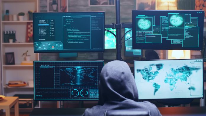 Back view of cyber terrorist using supercomputer La principale vulnerabilità