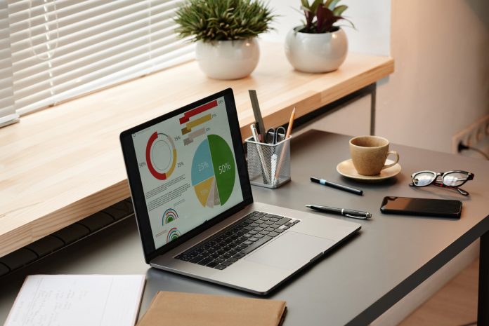Examining financial graphs on laptop Professioni tech