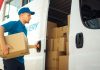 Courier Takes out Cardboard Box Package from Openned Delivery Van and Closes the Door. Delivering Postal Parcel to Customer.