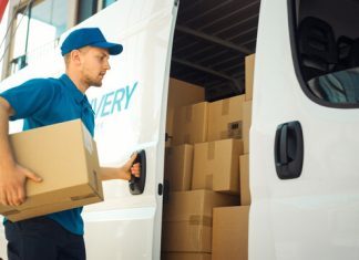 Courier Takes out Cardboard Box Package from Openned Delivery Van and Closes the Door. Delivering Postal Parcel to Customer.